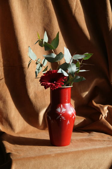 Красная ваза с белым орнаментом
