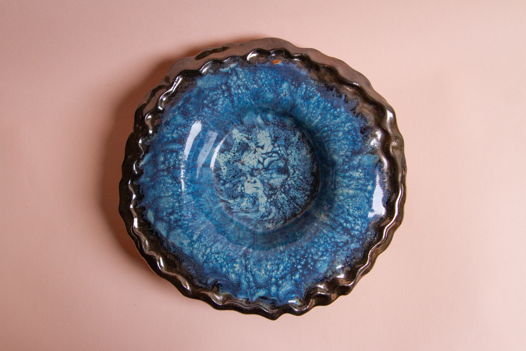 Широкополая тарелка для пасты ручной работы, выполненная из бежевой в крапинку глины, покрытая несколькими оттенками голубой и синей глазурей, а также бронзовой глазурью