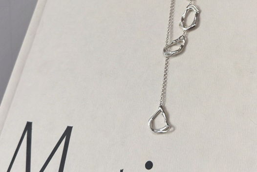 Колье-галстук "Живые формы" в виде звеньев в форме мятых овалов.