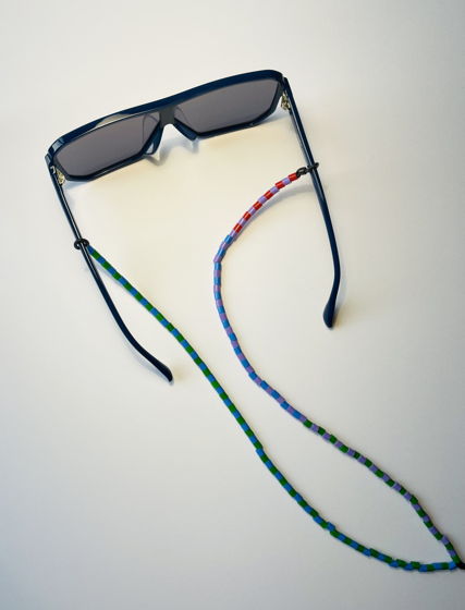 Холдер цепочка для очков асимметричного дизайна  из пластиковых бусин зеленого, голубого, сиреневого и красного цветов.