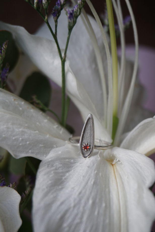 Серебряное кольцо с гранатом текстурное в форме узкой капли.