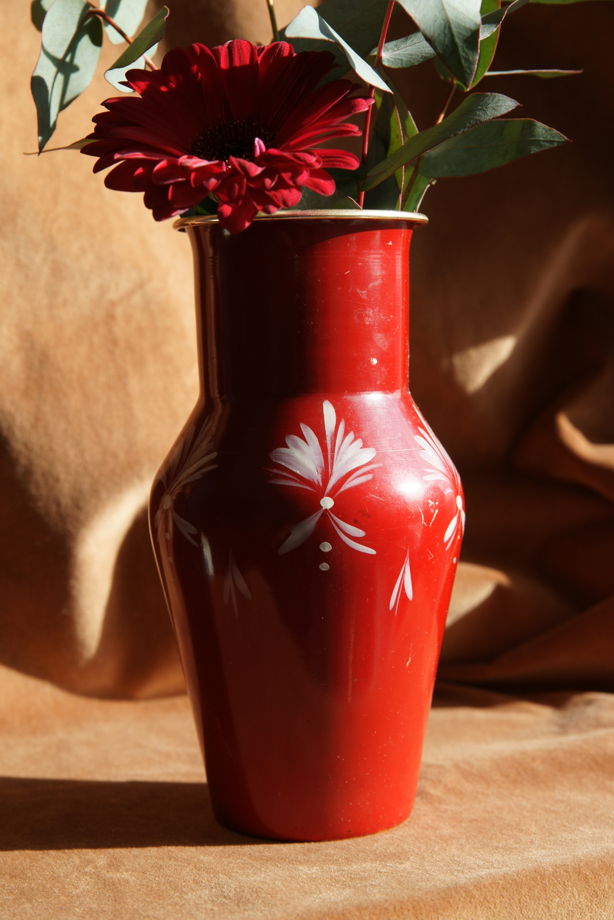 Красная ваза с белым орнаментом
